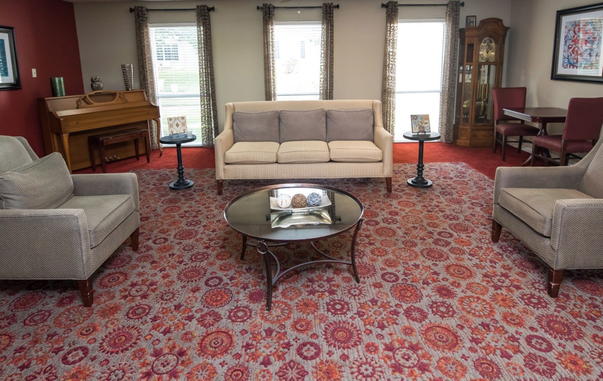 A cozy living room with a patterned carpet and comfortable seating.