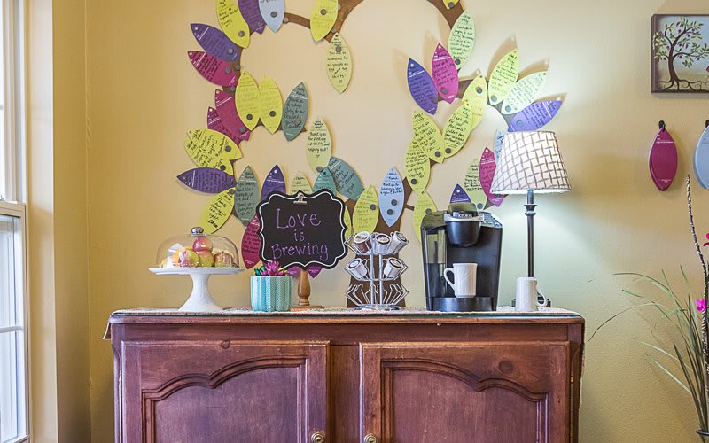 A cozy fall-themed kitchen counter with a thankful tree, coffee maker, and sweet treats.