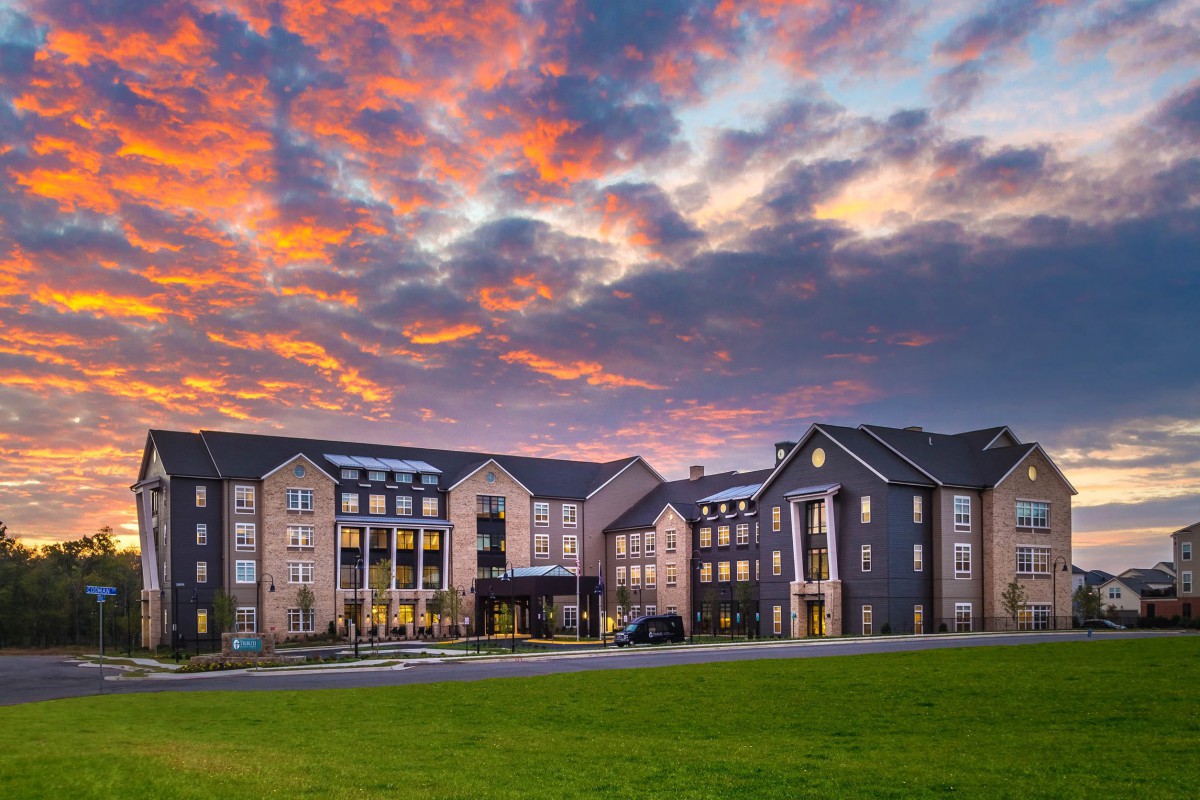 A hotel building with a dramatic sunset sky in the background.