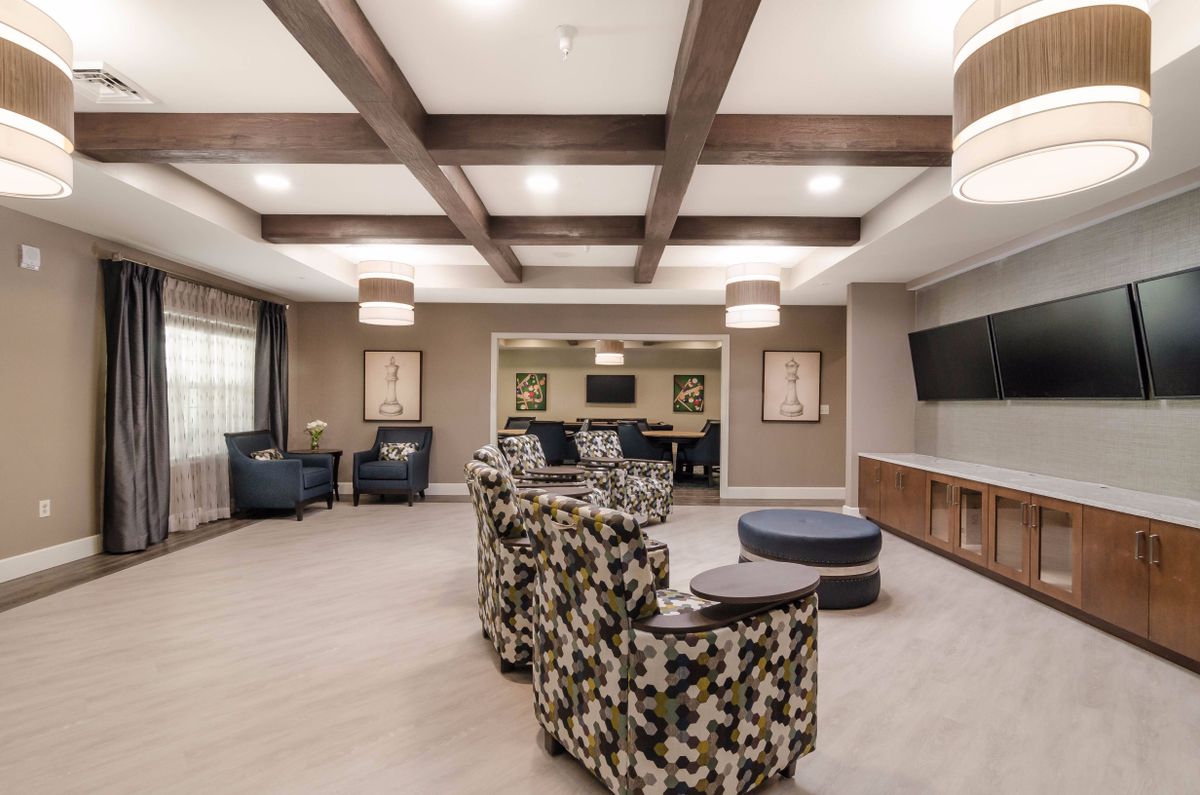 A modern lounge area with stylish armchairs and ceiling beams.