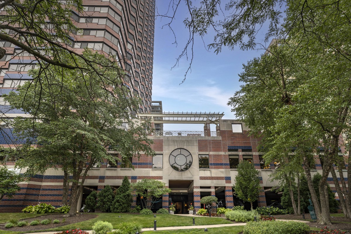 A view of a modern building with surrounding greenery and trees.