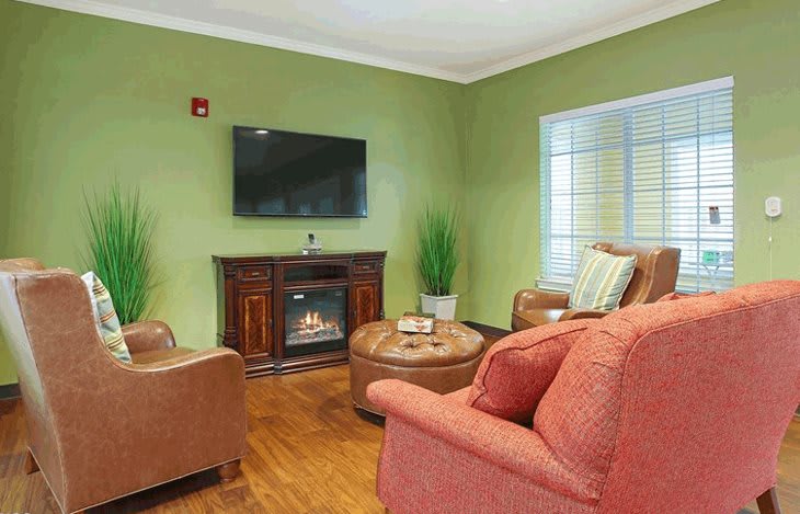 Cozy living room with comfortable seating, a fireplace, and a wall-mounted TV.