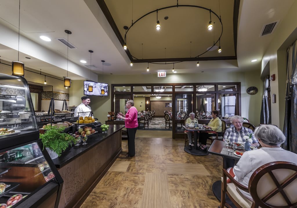 A modern cafe with people dining and staff behind the counter.