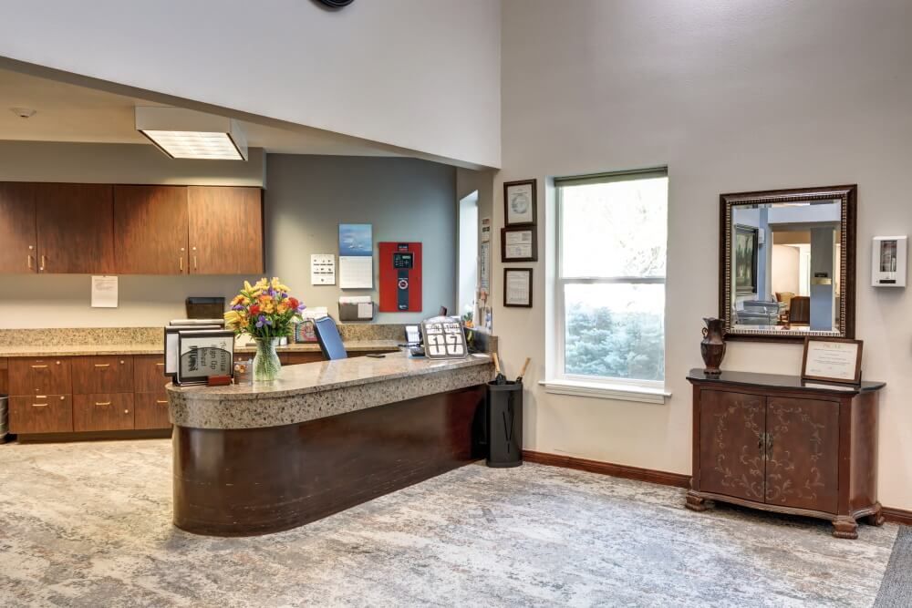 A modern office reception area with a curved desk and decorative elements.