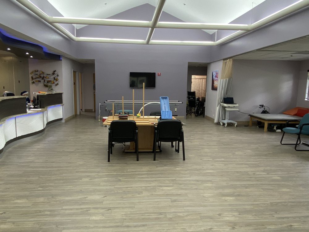 A modern office meeting room with a conference table and chairs.