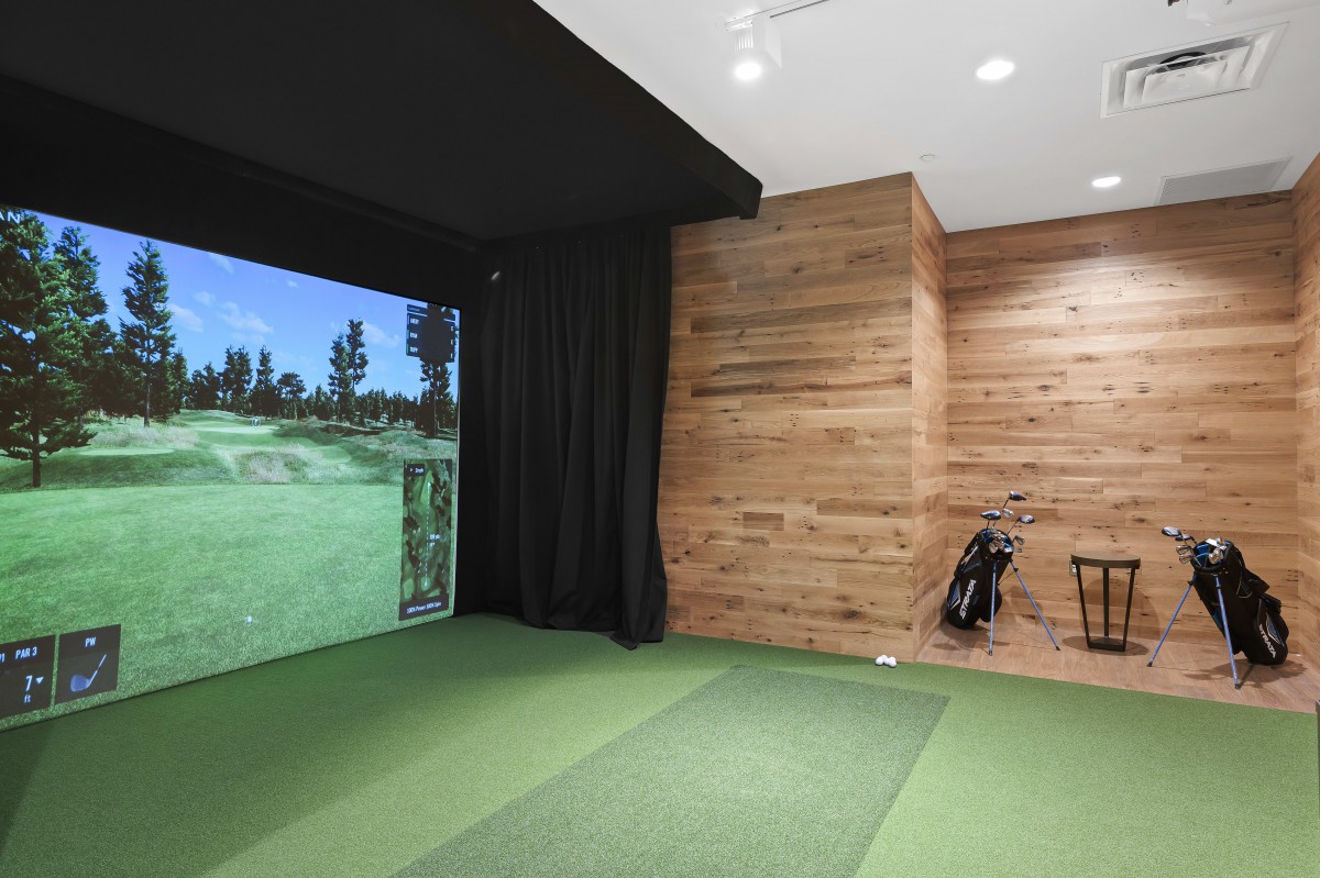 An indoor golf simulator setup with realistic virtual course and golf bag.