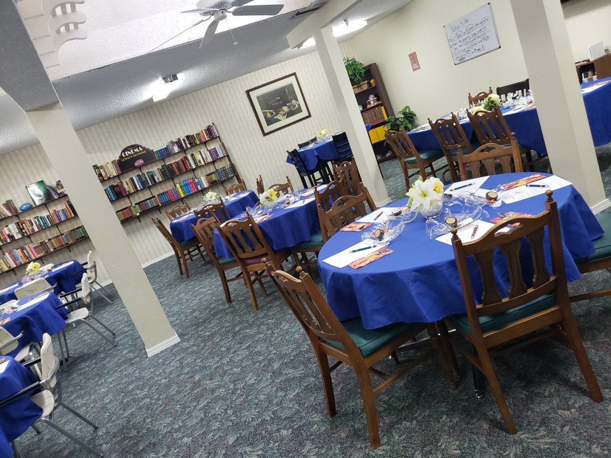 A cozy dining area with blue tablecloths and bookshelves.
