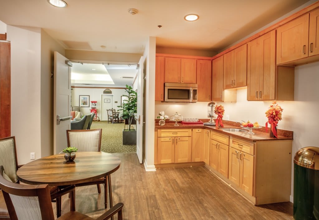 A cozy, modern kitchen and dining area with wooden cabinets and warm lighting.