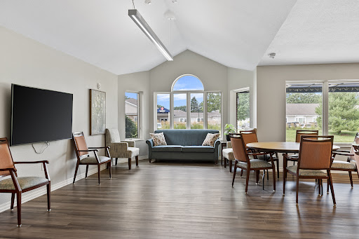 A bright and airy living space featuring comfortable seating, large windows, and a modern aesthetic.