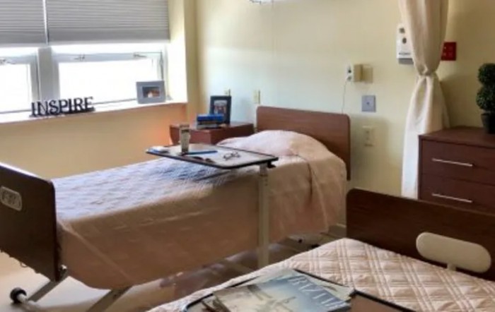 A clean and organized hospital room with two beds.