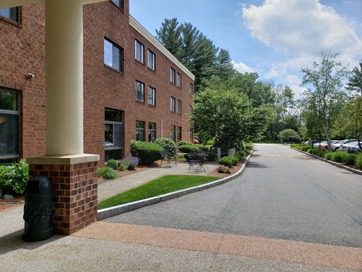 A welcoming view of a hotel building surrounded by greenery and a well-maintained pathway.