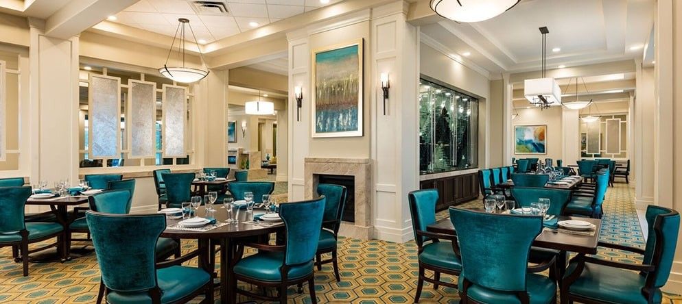 A well-decorated restaurant dining area with teal chairs and neatly set tables.