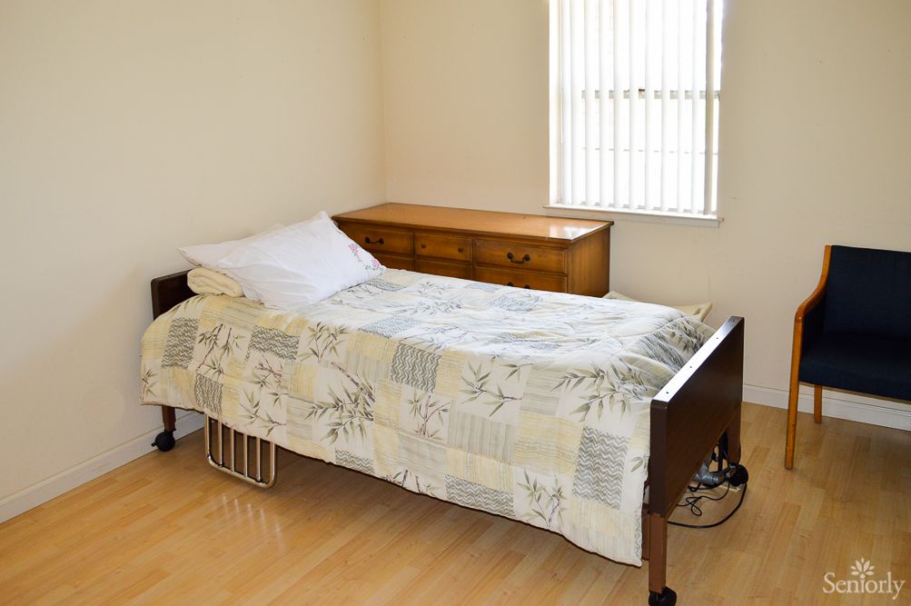 A minimalist bedroom with a single bed and wooden dresser.