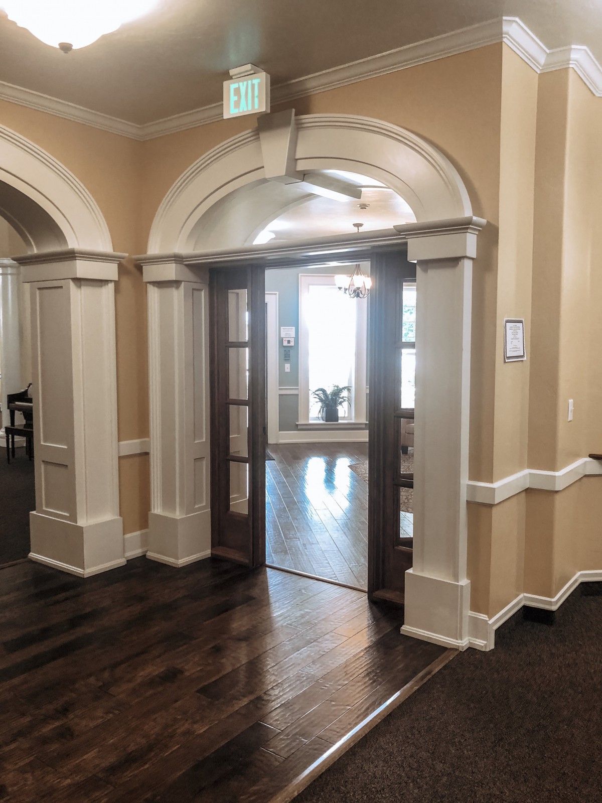 A traditional interior with an arched doorway and wood flooring.