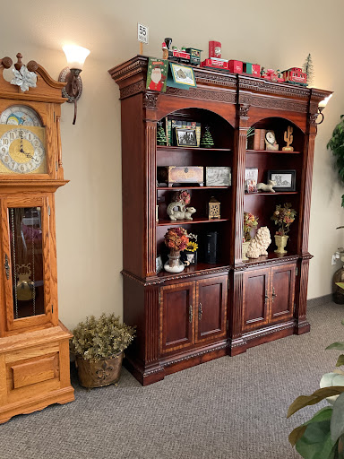A cozy living room setup featuring a wooden bookshelf and an antique clock.