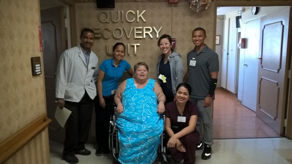 A group of hospital staff and a patient in the Quick Recovery Unit.