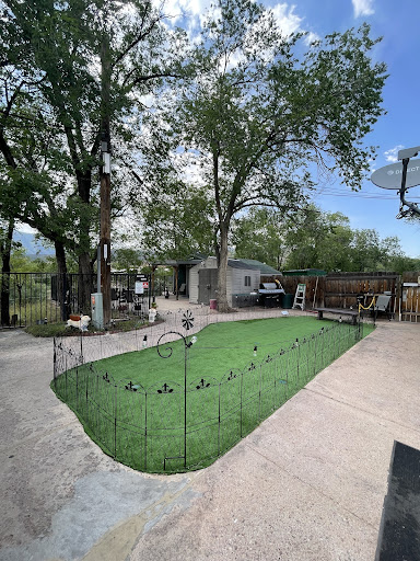 A serene backyard garden featuring lush green grass, surrounded by trees and equipped with a patio area.