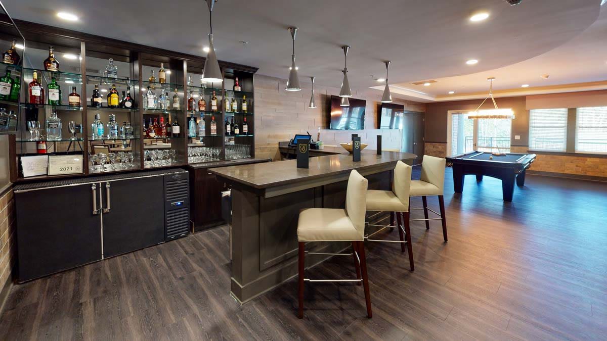 A modern home bar with elegant seating and stylish pendant lighting.