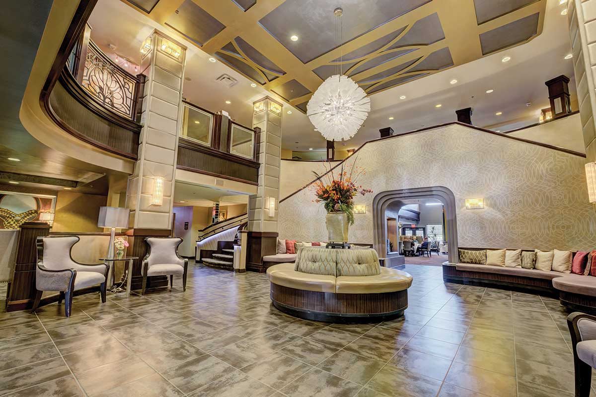 A luxurious hotel lobby with elegant seating and a grand chandelier.