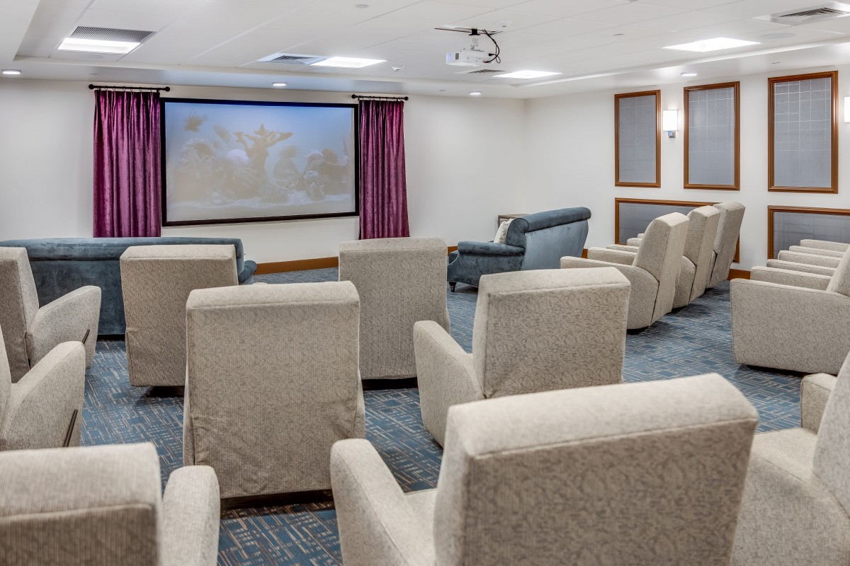 A cozy home theater setup with comfortable seating and a large projector screen.