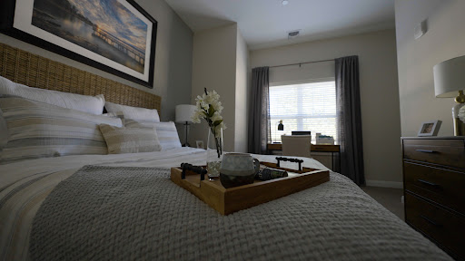 A cozy and elegantly styled bedroom featuring a comfortable bed, soft bedding, and a decorative tray with flowers.