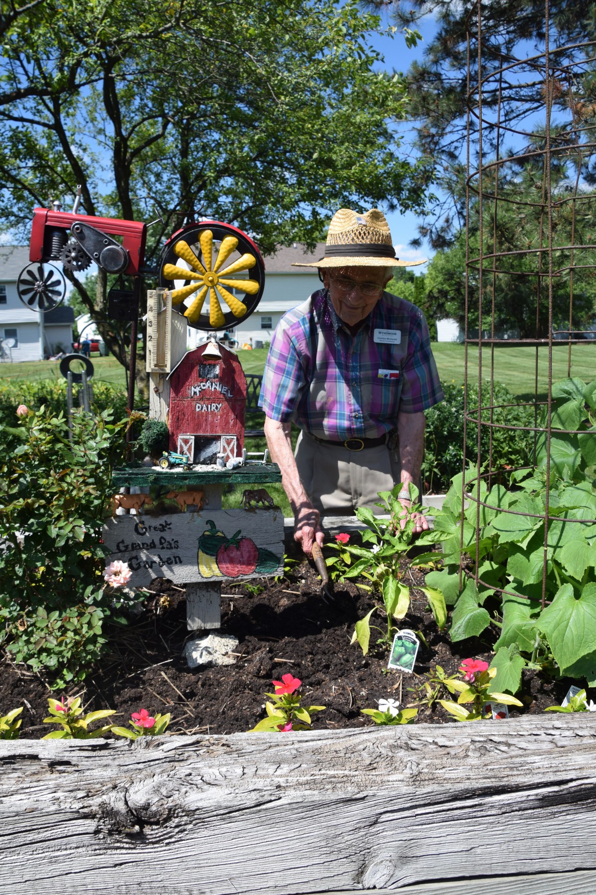 A person tending to a garden with various plants and decorative items.