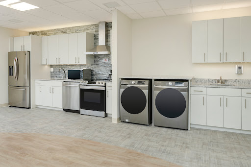 A modern kitchen featuring stainless steel appliances, including a washer and dryer.