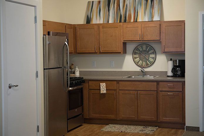 A modern kitchen with wooden cabinets, stainless steel appliances, and decorative artwork.