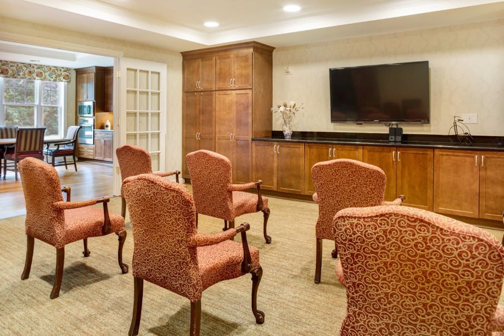 A well-arranged meeting room with chairs facing a large television screen.