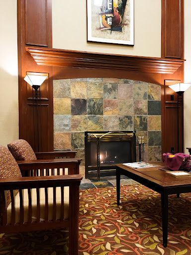 A cozy lobby area featuring comfortable seating and a decorative fireplace.