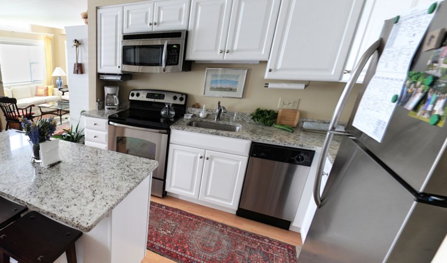 A modern kitchen with white cabinets and stainless steel appliances.