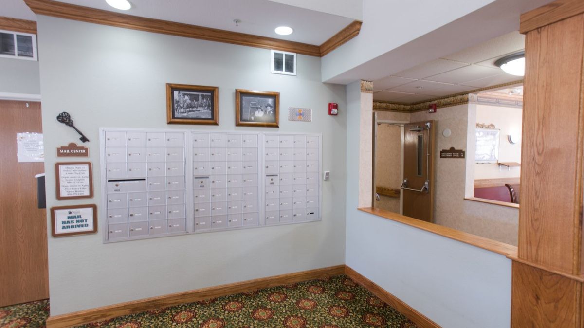 A lobby area with a wall of mailboxes, decorated with framed pictures and a counter.