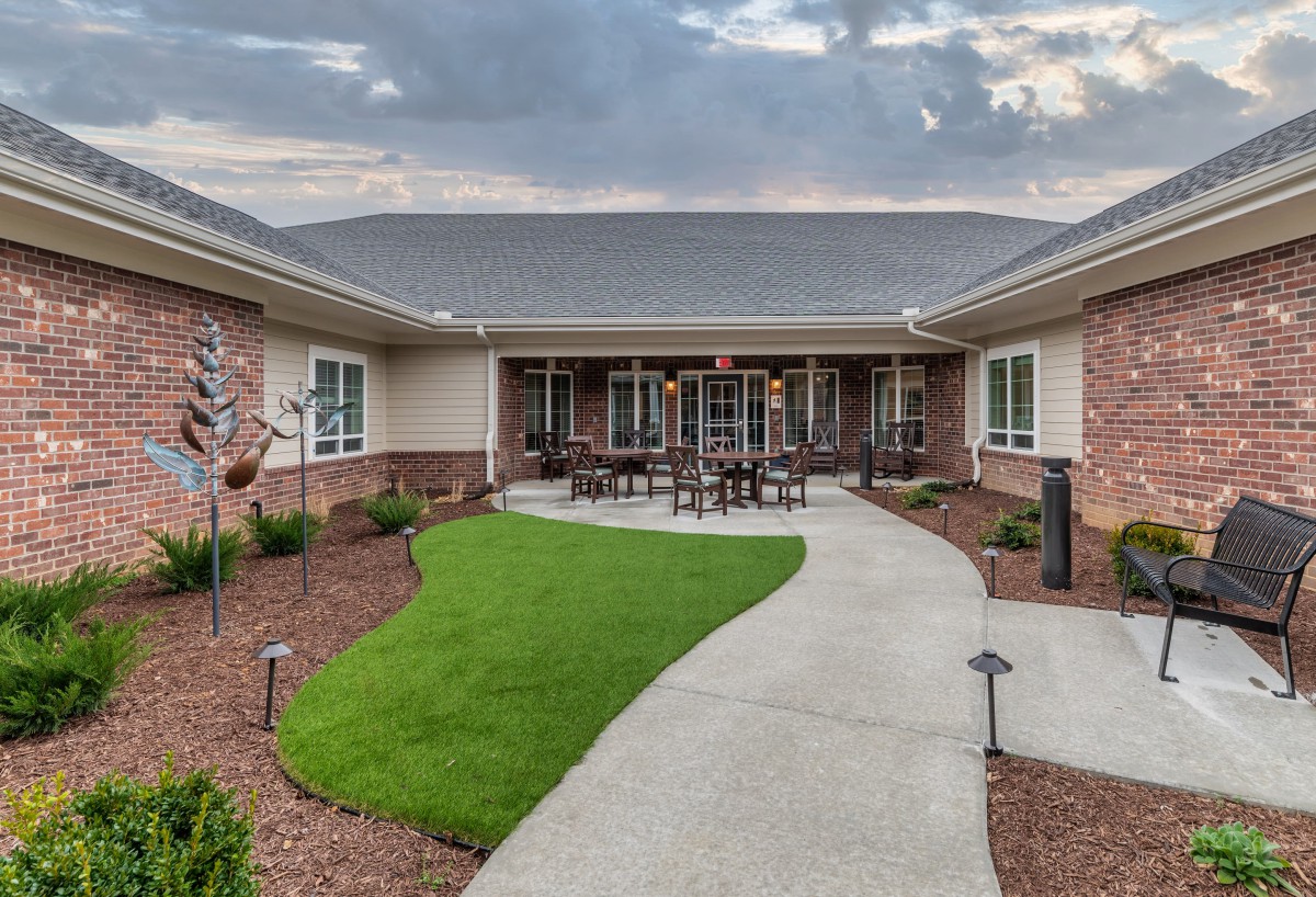 A well-maintained courtyard with a central pathway and surrounding building.
