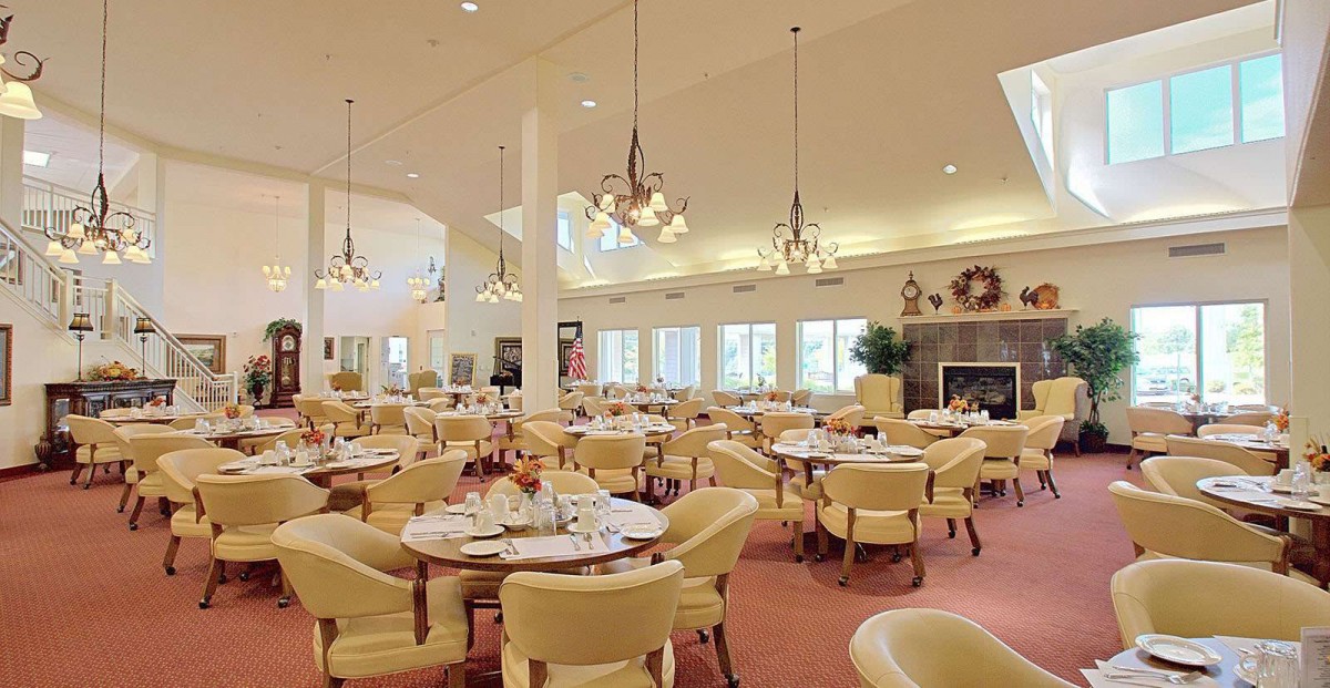 A spacious and elegantly designed dining area with neatly arranged tables and comfortable seating.
