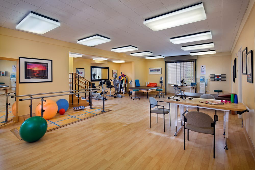 A well-equipped physical therapy room featuring various exercise equipment and a spacious layout for rehabilitation activities.