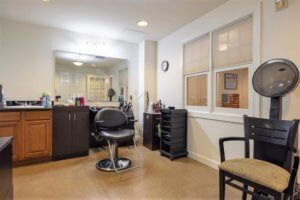 A modern hair salon interior with styling chair and mirror.