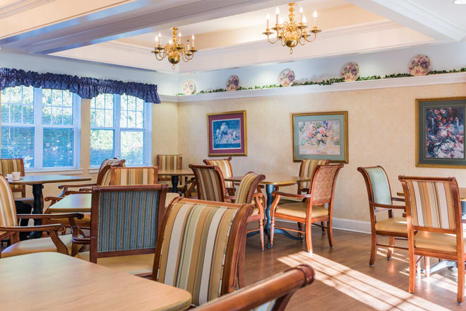 A cozy dining room with elegant chandeliers and comfortable seating.