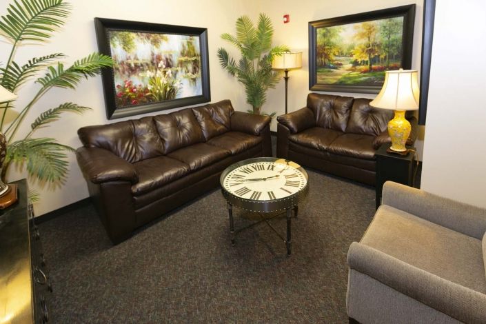 A cozy living room with leather sofas, a decorative coffee table, and wall art.