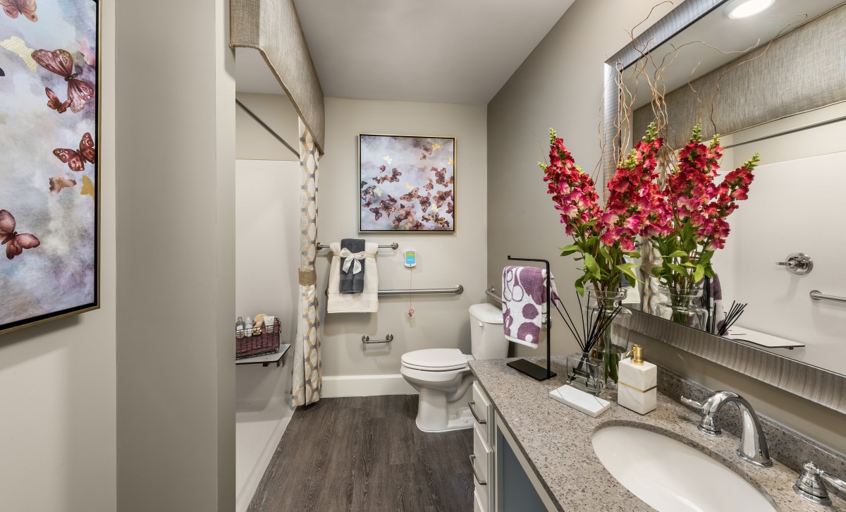 A modern bathroom with floral decor and stylish artwork.