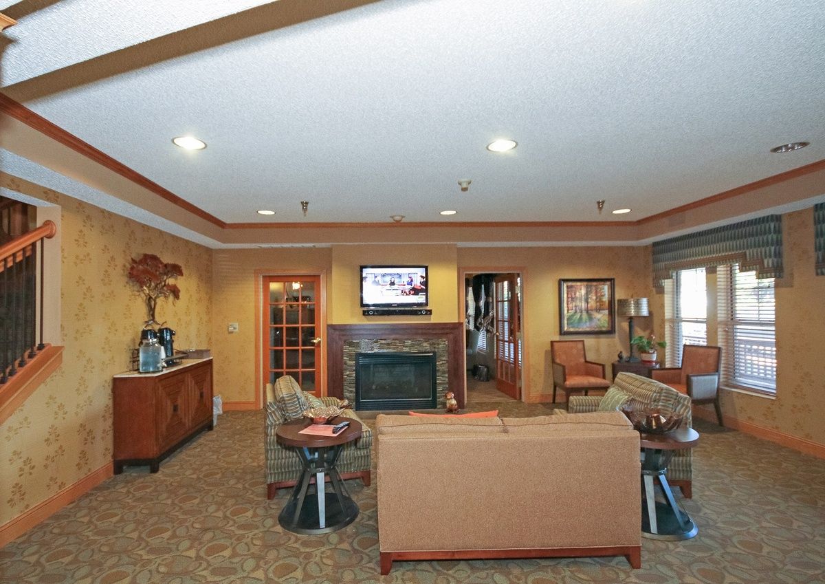 A cozy living room with a sofa facing a television and fireplace.