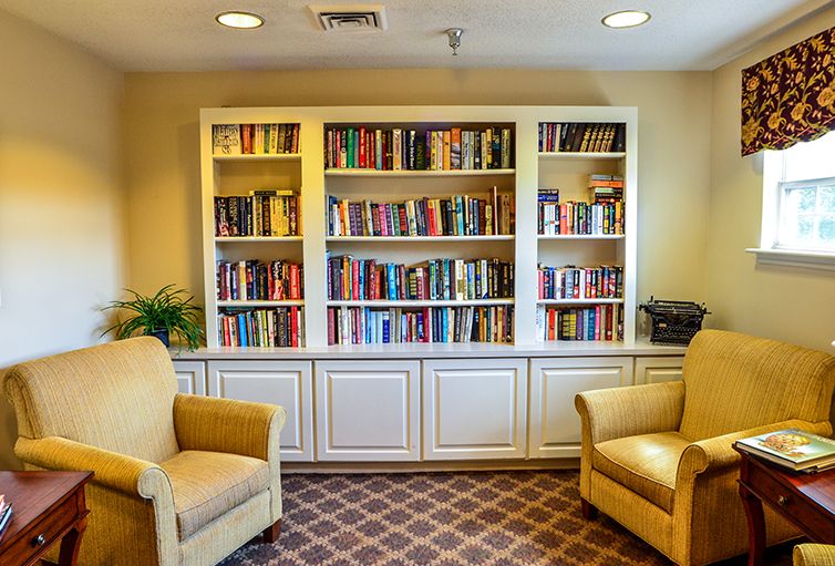 A cozy reading area featuring a well-stocked bookshelf and comfortable chairs.