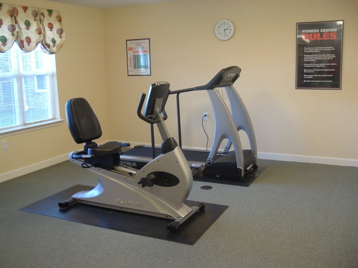 A small gym with a treadmill and a stationary bike.