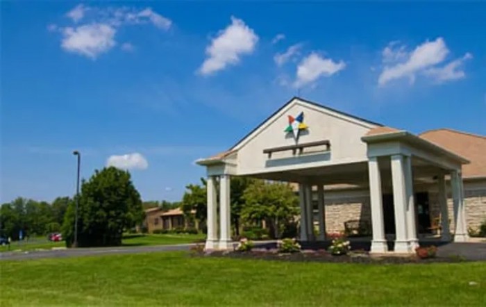 A building entrance with columns under a clear blue sky.