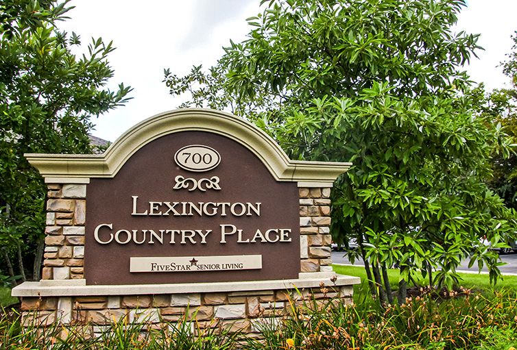 Entrance sign for Lexington Country Place surrounded by trees.