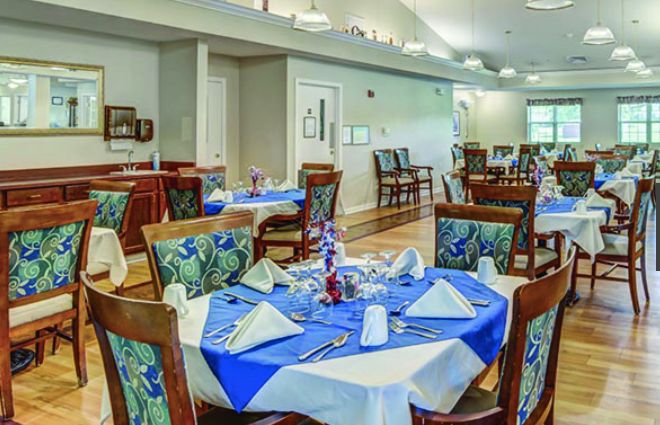 A well-arranged dining area with neatly set tables and colorful chairs.
