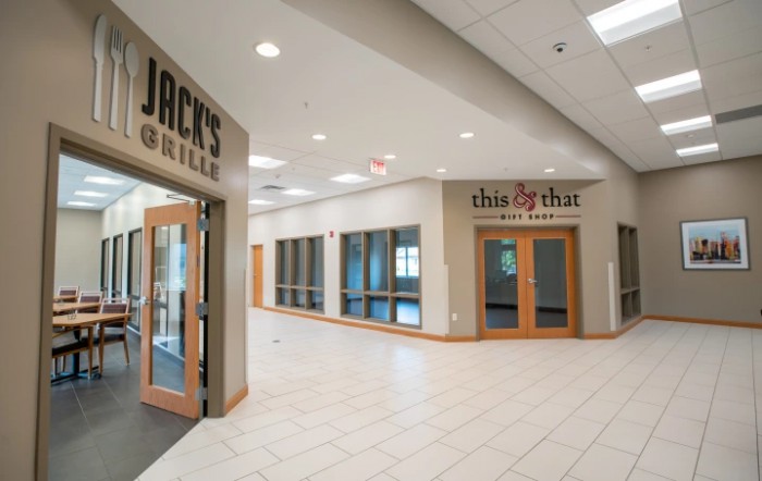 A corridor in a shopping center featuring storefront entrances.