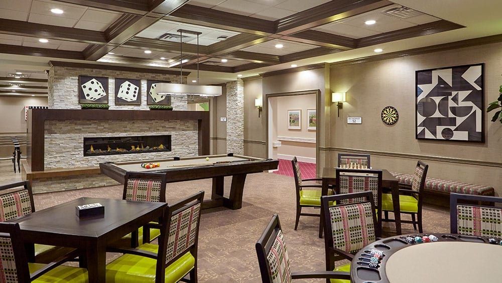 A modern game room featuring a shuffleboard table, comfortable seating, and elegant lighting.