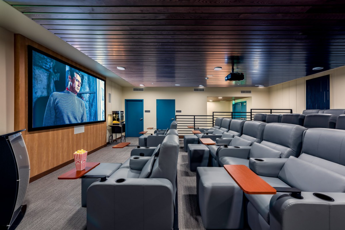 A modern home theater with comfortable recliner seating and a large screen.