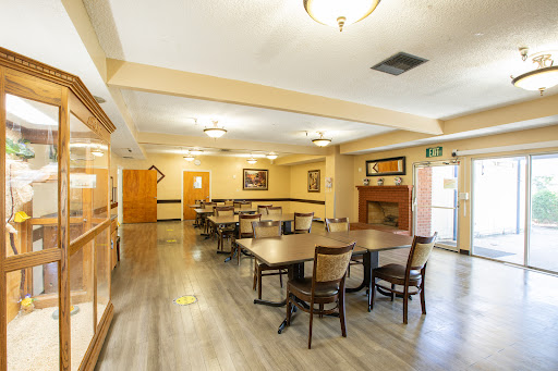 A spacious dining area with neatly arranged tables and chairs, illuminated by ceiling lights.