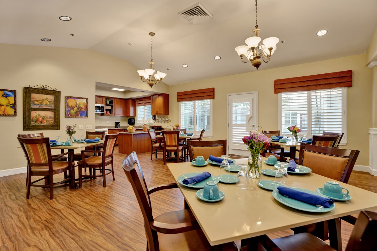 A well-appointed dining room with elegantly set tables and a view of the kitchen.